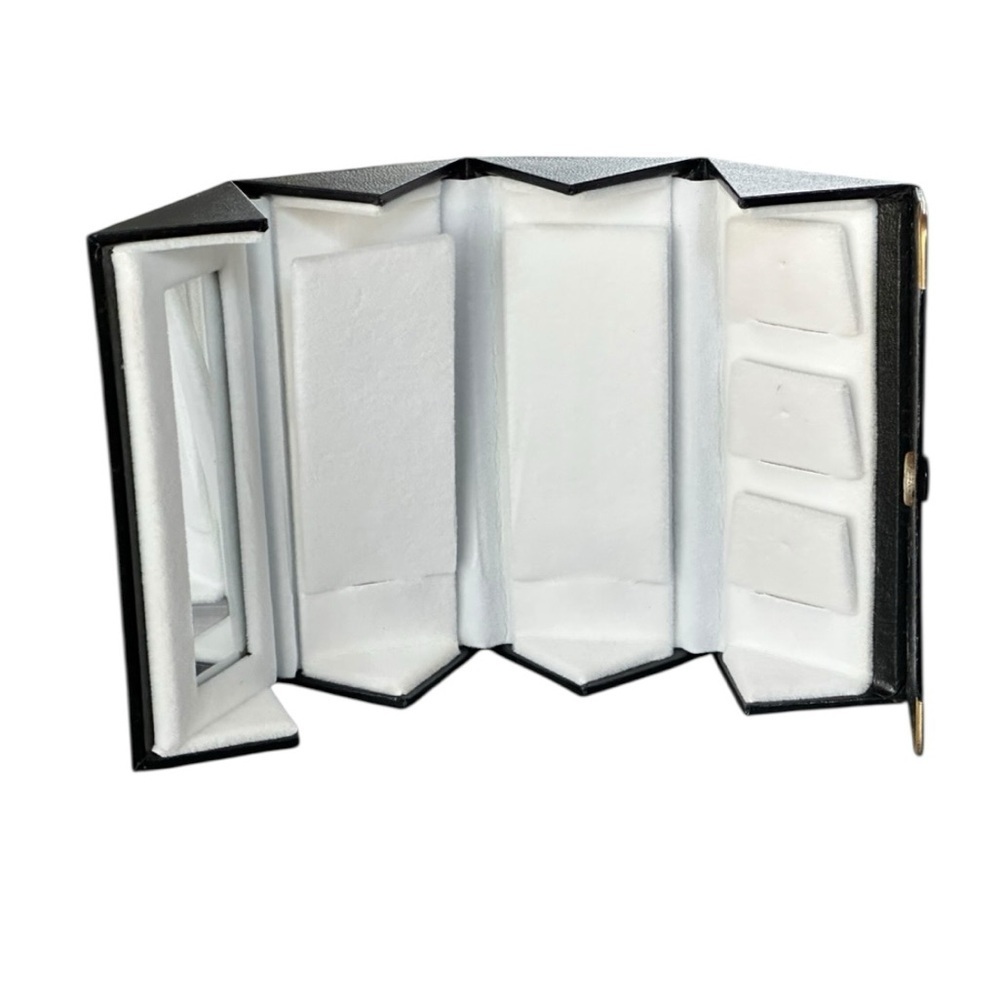 Black faux leather travel jewelry case with multiple compartments and a mirror